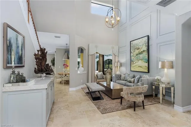 a living room with furniture a chandelier and a flat screen tv