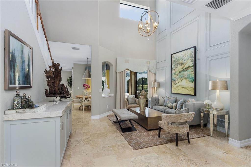 3423 Runaway Court Naples, FL 34114 - Photo 7 of 35 a living room with furniture a chandelier and a flat screen tv