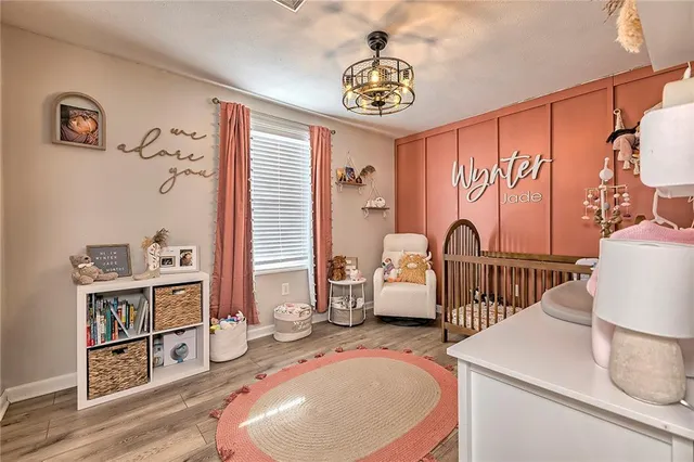 a bedroom with baby crib and wooden floor