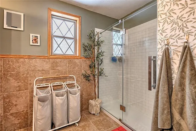 a backyard of a house with large trees and wooden fence