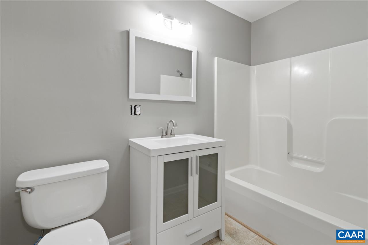 3915 Stage Junction Road Columbia, VA 23038 - Photo 10 of 11 a white toilet sitting next to a bathroom sink and tub