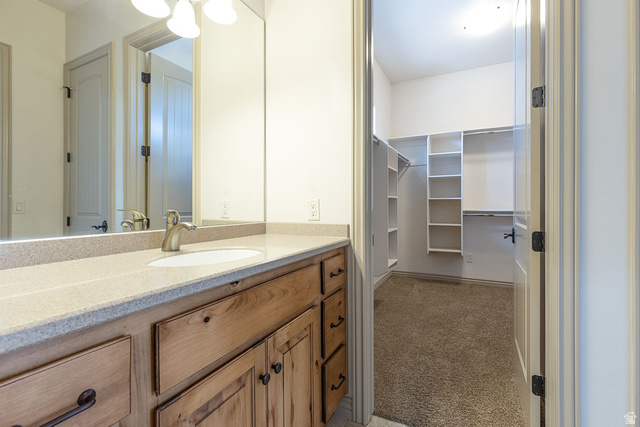 888 East Fiddlers Canyon Road Cedar City, UT 84721 - Photo 26 of 74 Full bath with vanity, a walk in closet, and light carpet