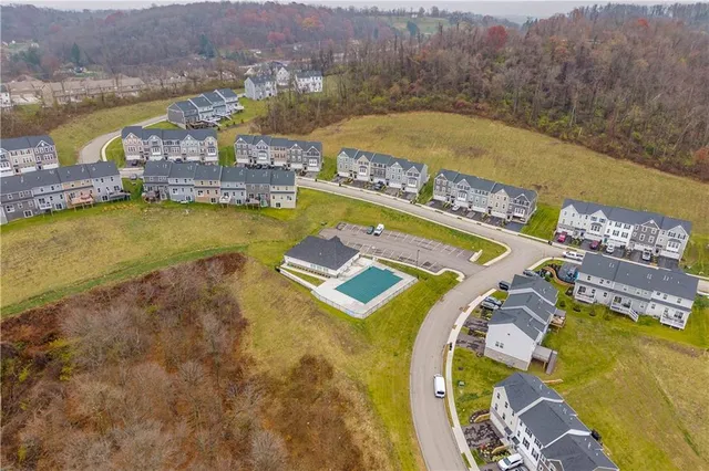 an aerial view of residential houses with outdoor space and swimming pool