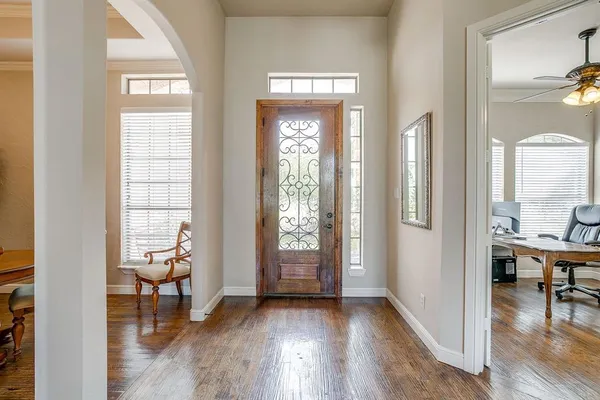 a view of a hallway with wooden floor and a dining room