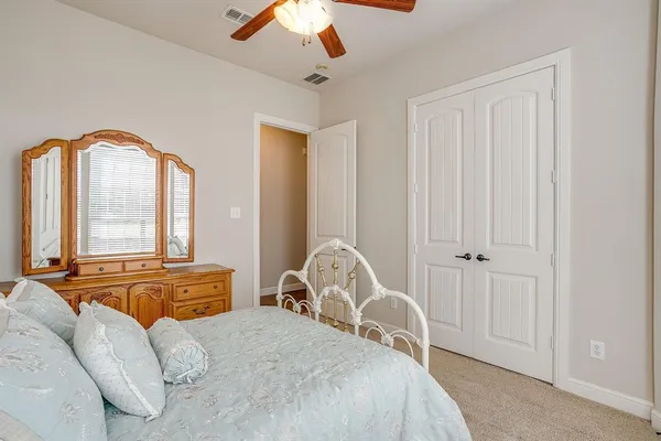 a bedroom with a bed and a large mirror