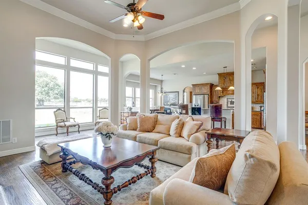 a living room with furniture a chandelier and a large window