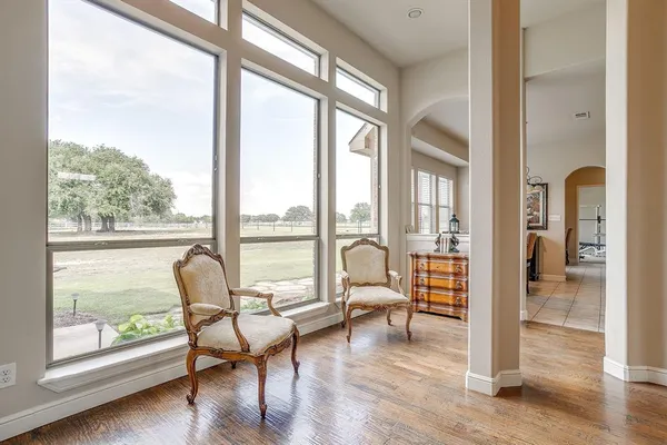 a living room with furniture and a large window with wooden floor