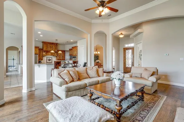 a living room with furniture a dining table and a chandelier