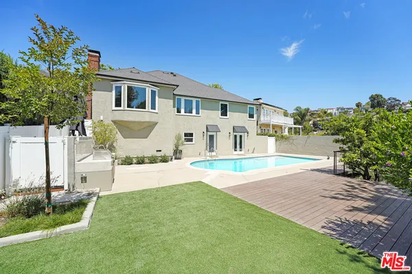 a view of a house with backyard and sitting area