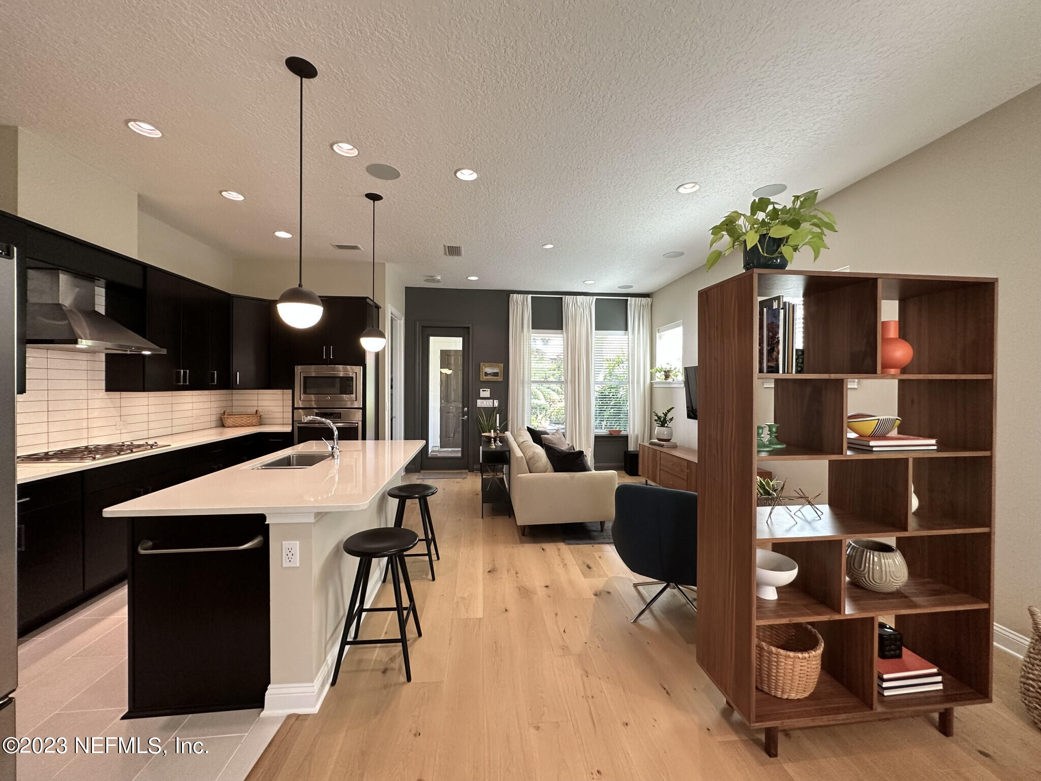 44 Rinaldo Way Ponte Vedra, FL 32081 - Photo 11 of 30 a kitchen with stainless steel appliances kitchen island granite countertop a refrigerator a stove and a sink with wooden floor