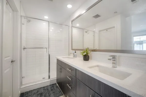 a bathroom with a shower sink and mirror