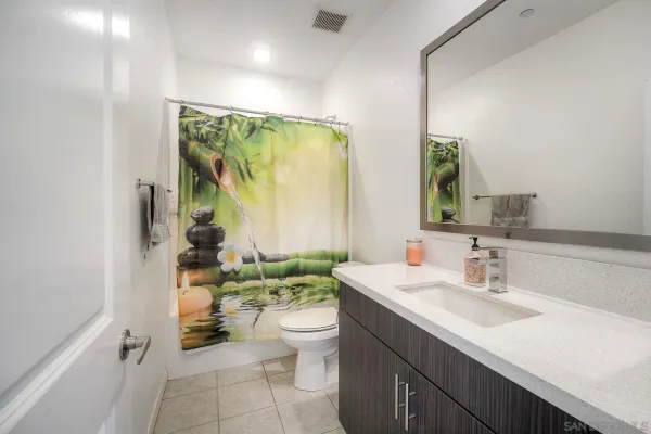a bathroom with a double vanity sink toilet and a mirror