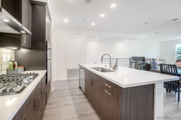 a large white kitchen with a sink and a stove top oven