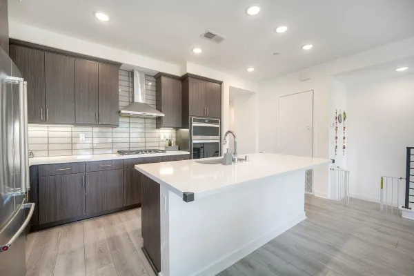 a large kitchen with kitchen island a sink stainless steel appliances and cabinets