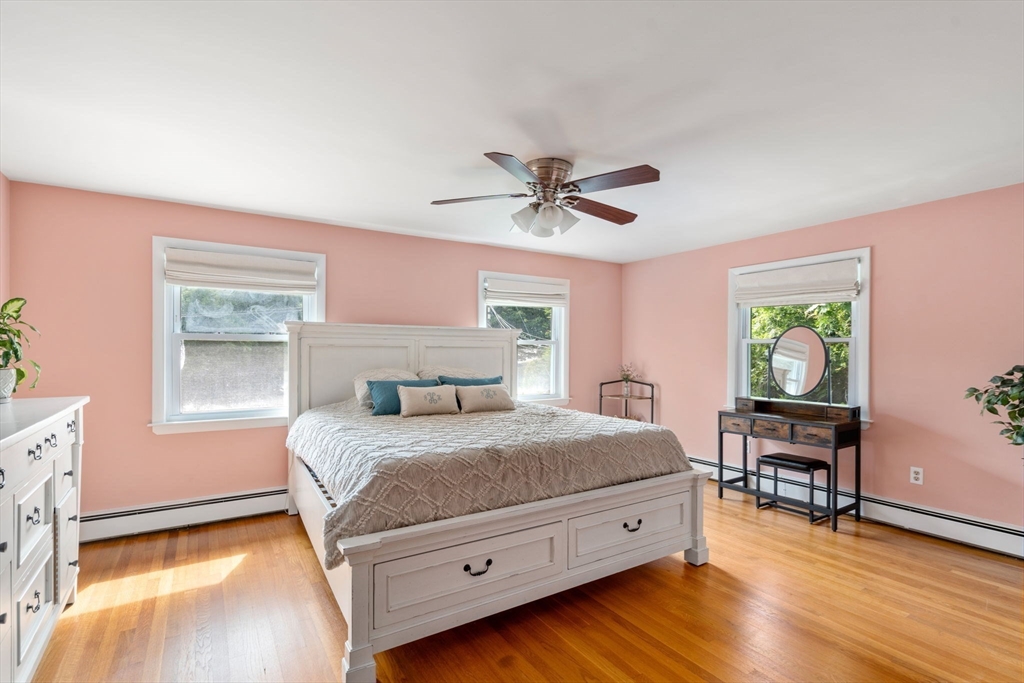 3 Community Road Marblehead, MA 01945 - Photo 16 of 37 a bedroom with a bed and a table in it with wooden floor