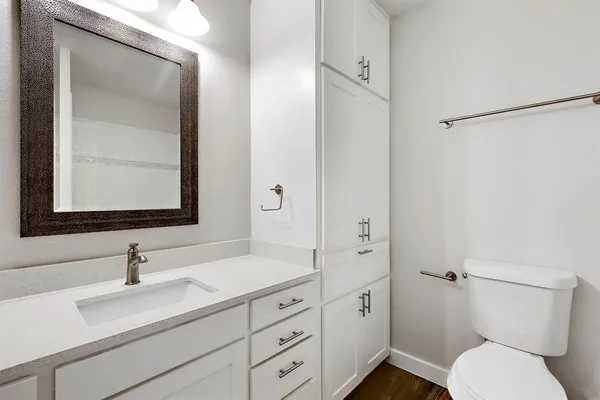 a bathroom with a sin toilet granite vanity and mirror