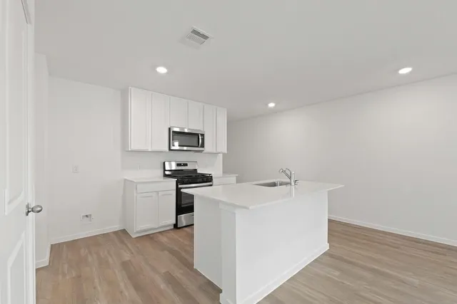 a kitchen with stainless steel appliances granite countertop a sink stove and refrigerator