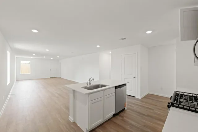a kitchen with a sink and wooden floor