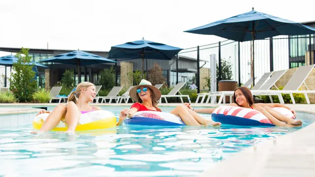 a view of small pool with lawn chairs under an umbrella