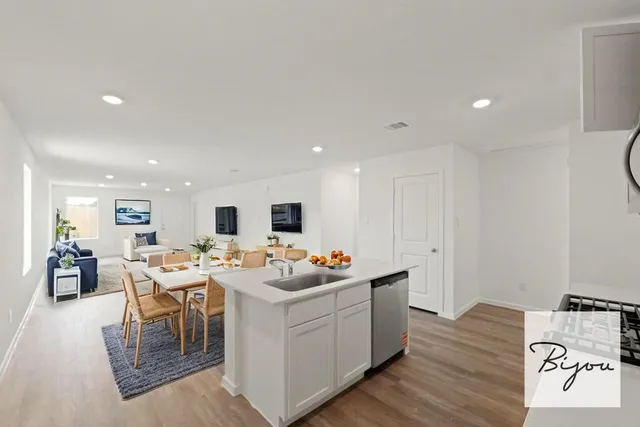 a kitchen with a sink and wooden floor