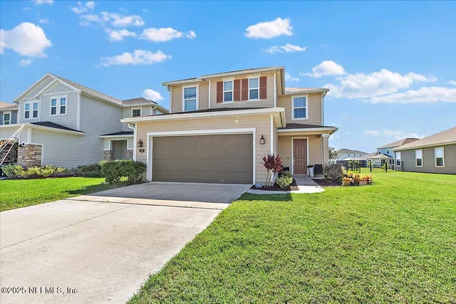 a front view of a house with a yard and garage