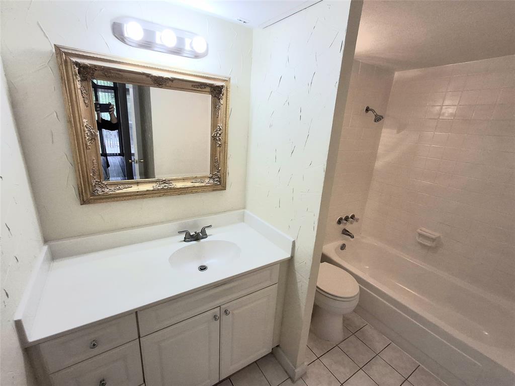 4859 Cedar Springs Road, Unit 358 Dallas, TX 75219 - Photo 6 of 12 Full bath featuring vanity, washtub / shower combination, and light tile patterned flooring