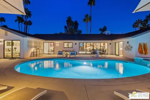 a view of a swimming pool with a dining table and chairs