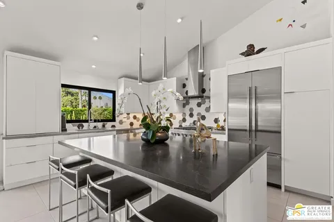 a kitchen with kitchen island a counter space a sink appliances and dining table