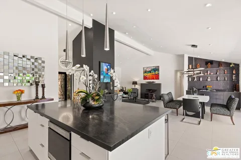 a kitchen with stainless steel appliances kitchen island granite countertop a table and chairs in it