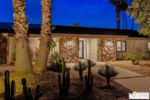 a view of a patio with table and chairs potted plants and a palm tree