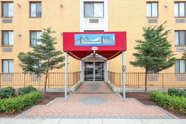 a view of a building with a small yard and wooden fence