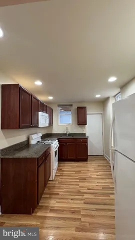 a large kitchen with stainless steel appliances granite countertop a large counter top a sink and a stove