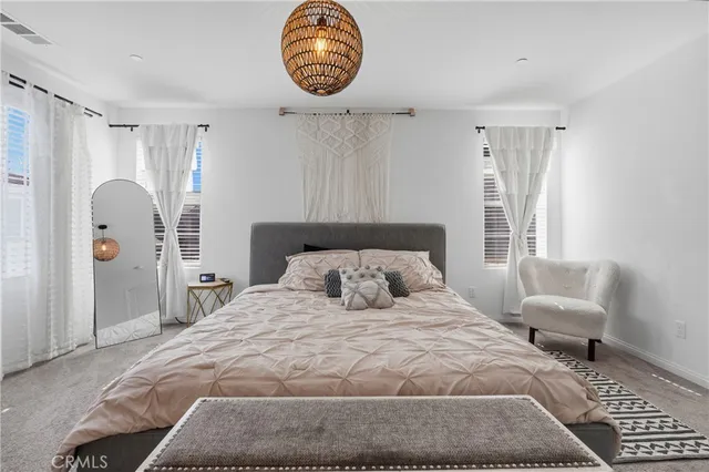 a bedroom with a bed window and a flat screen tv