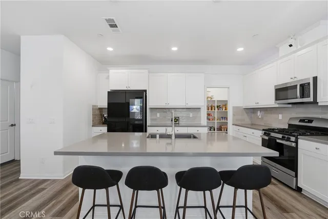 a kitchen with granite countertop a table chairs microwave and cabinets