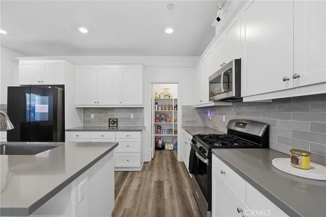 a kitchen with kitchen island granite countertop stainless steel appliances lots of counter space and a sink