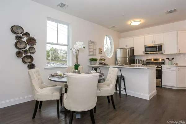 a kitchen with kitchen island a dining table chairs and a sink