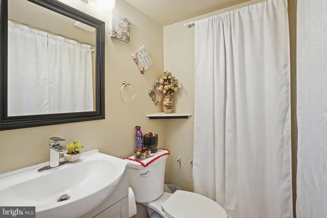 a bathroom with a sink a toilet and a mirror