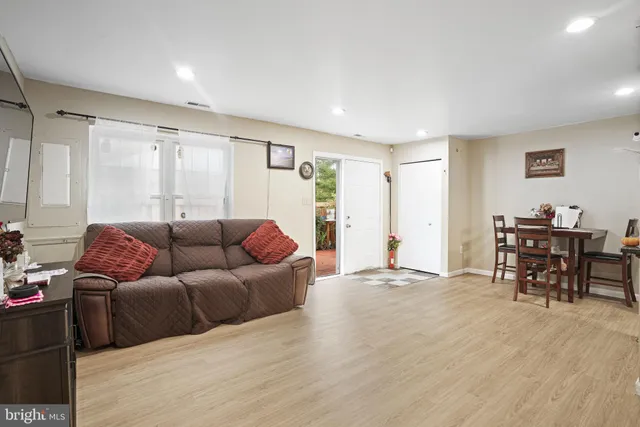 a living room with furniture and a dining table with wooden floor
