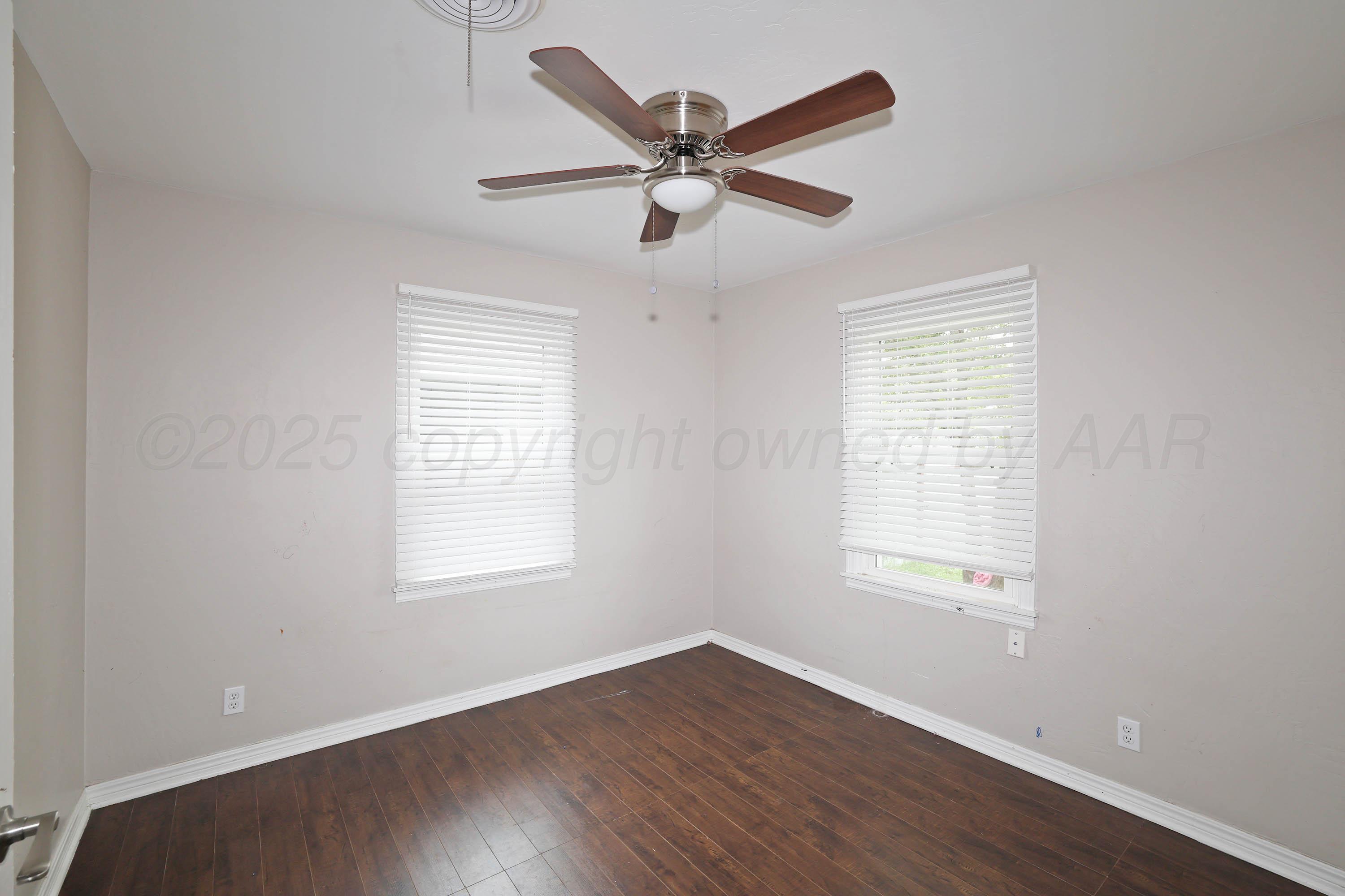 4112 South Tyler Street Amarillo, TX 79110 - Photo 12 of 20 a view of an empty room with wooden floor and a window