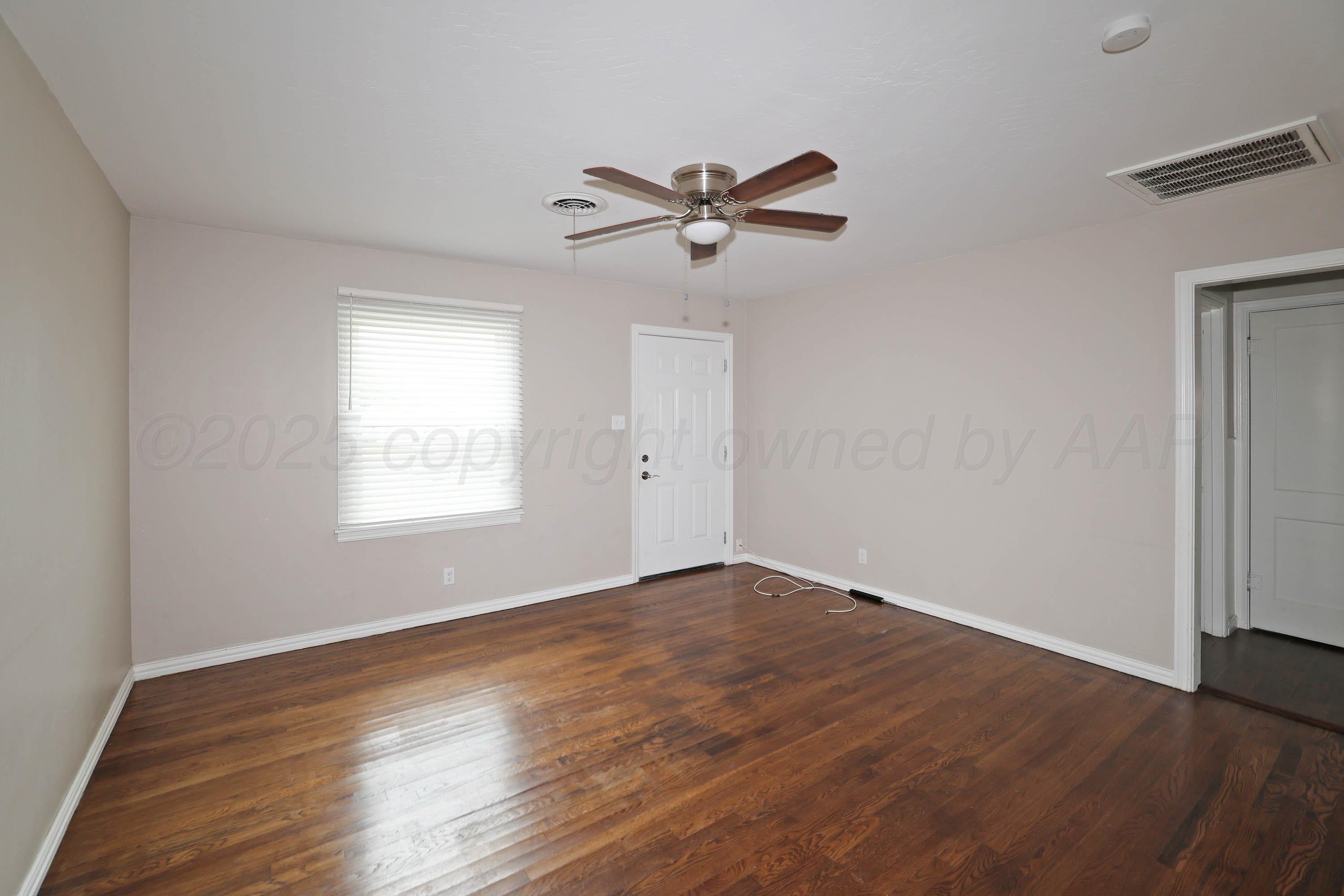 4112 South Tyler Street Amarillo, TX 79110 - Photo 5 of 20 a view of empty room with wooden floor and fan