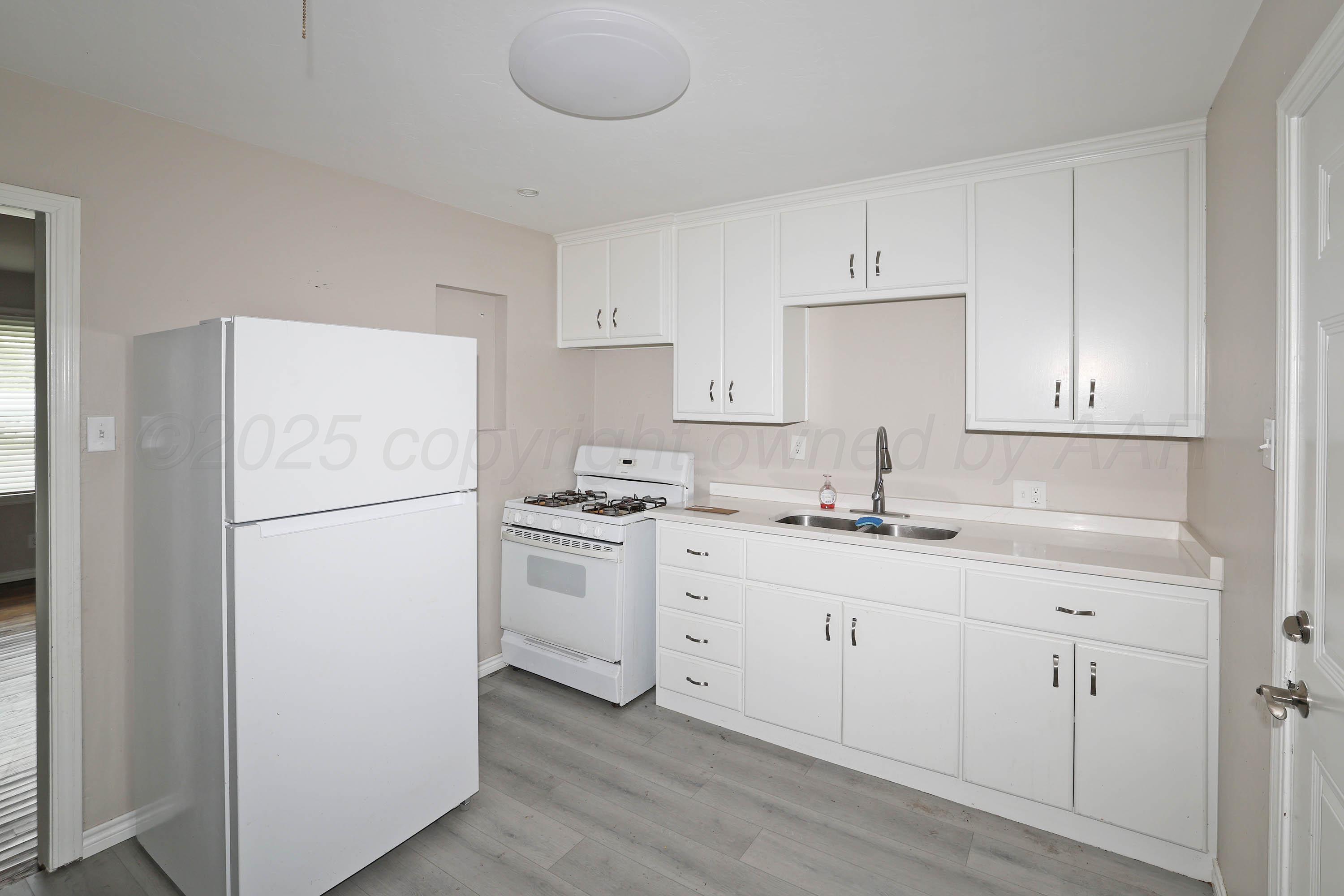4112 South Tyler Street Amarillo, TX 79110 - Photo 7 of 20 a kitchen with appliances a sink and a refrigerator