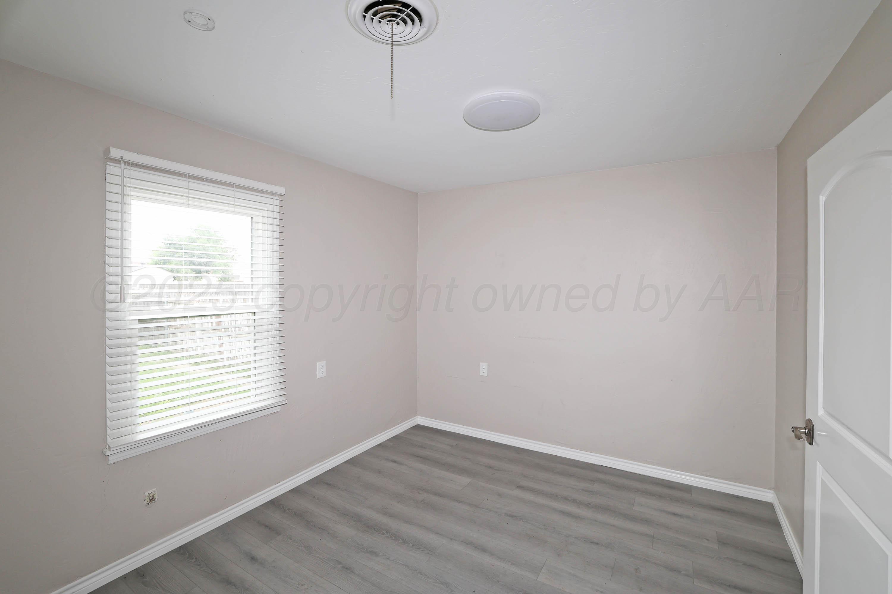 4112 South Tyler Street Amarillo, TX 79110 - Photo 9 of 20 a view of an empty room with wooden floor and a window