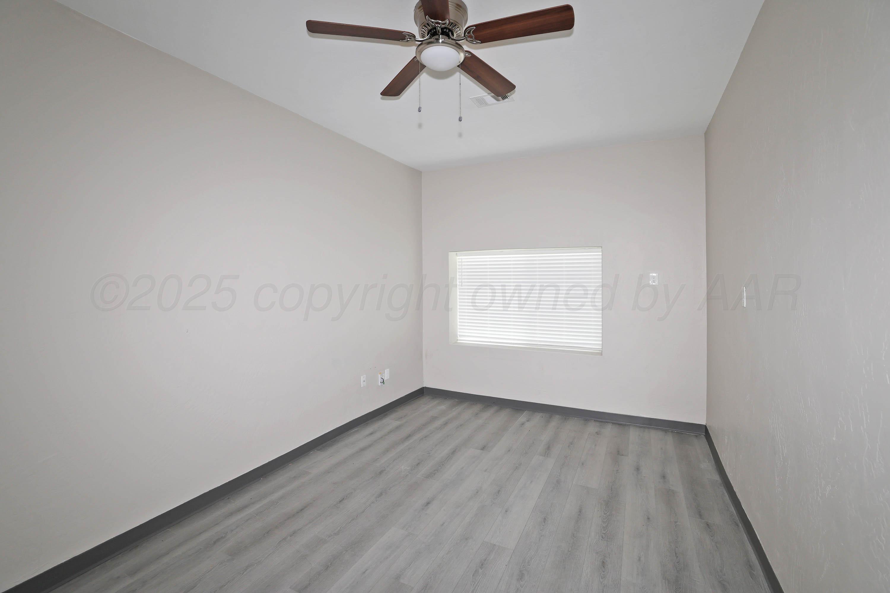 4112 South Tyler Street Amarillo, TX 79110 - Photo 10 of 20 a view of an empty room with wooden floor and a window