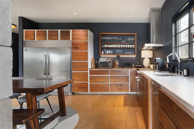 a kitchen with a wooden floor and a view of living room
