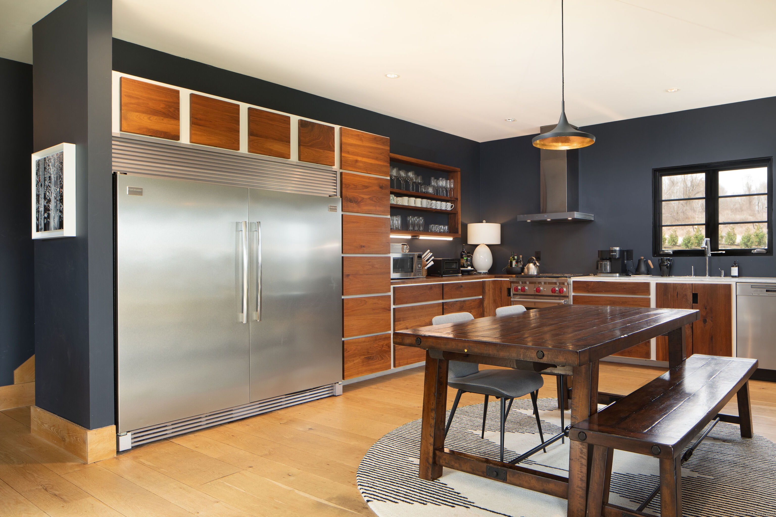 120 Lime Rock Road Salisbury, CT 06039 - Photo 12 of 35 a dining room with stainless steel appliances kitchen island granite countertop a table chairs and a refrigerator