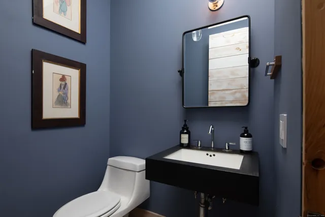 a bathroom with a toilet sink vanity and mirror
