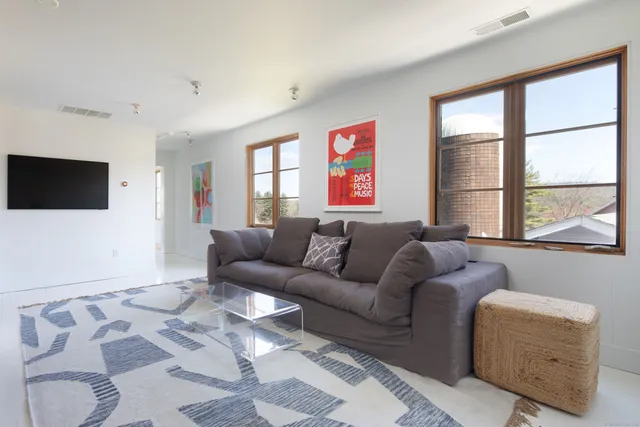 a living room with furniture a flat screen tv and a window