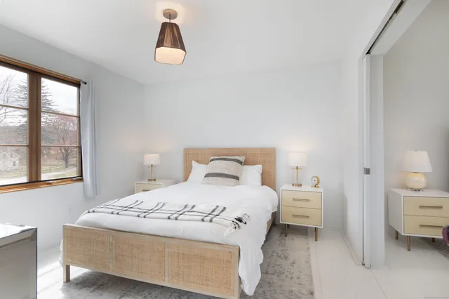 a bedroom with a bed and a window