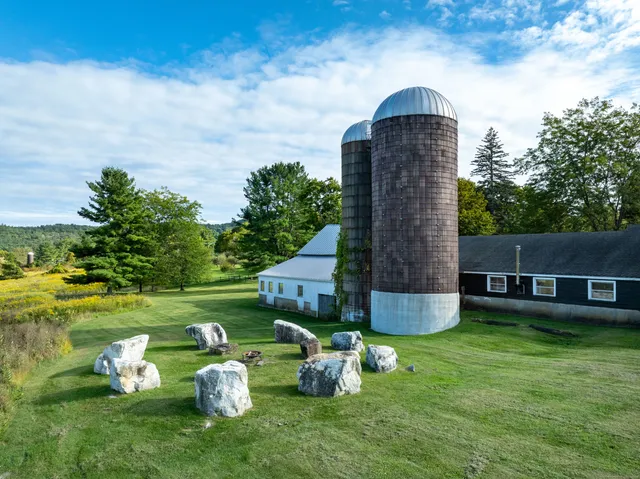 a backyard of a house with table and chairs plants and large tree