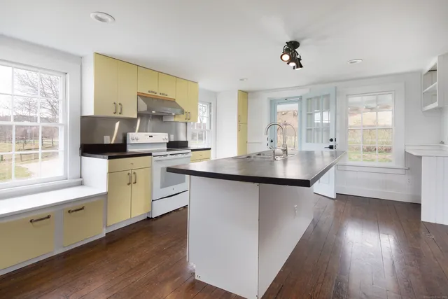 a kitchen with a sink cabinets and wooden floor